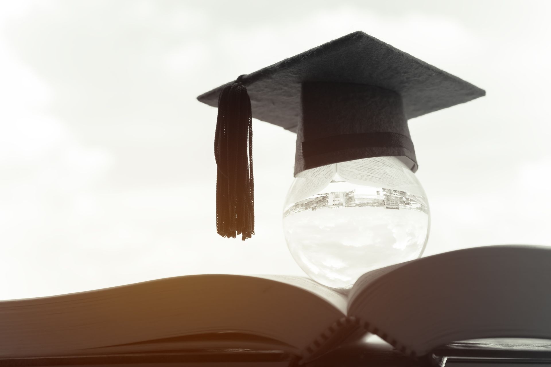Education in Global, Graduation cap on top crystal ball on textbook. Concept of abroad international Educational, Back to School and Studies lead to success in world wide. Black and white tone